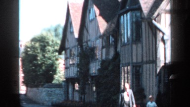 1957: man and boy walking in front of english tudor home on a sunny day. ENGLAND