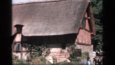 1957: People Gathered on a Sunny Day in Front of a Beautiful Old-Fashioned House