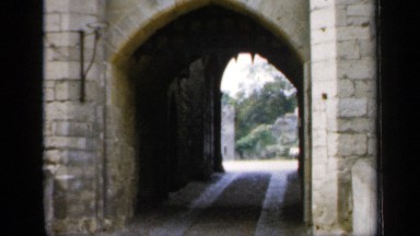1957: vehicle entry door in front of a castle area at a landmark, daytime scene