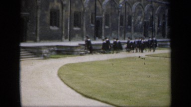 1957: british academics wear black robes as they walk along school building
