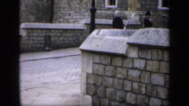 1957: a british guard is marching over a stone palace or castle, daytime scene