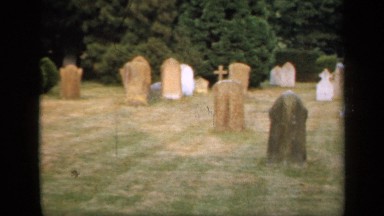 1957: green grass daytime at a graveyard with lot of grave signs beside graves