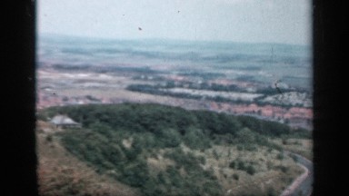 1957: an aerial view of an urban area abutting nearby farms and forest ENGLAND