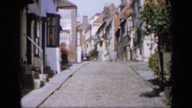 1957: A Young Woman Walking Along a Residential Country Road in England
