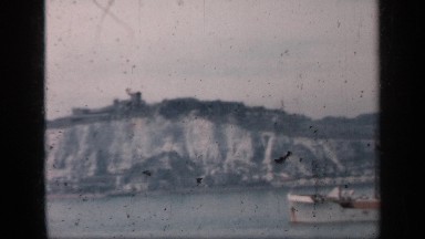 1957: a carrying ship is going over a big river, behind is a mountain day time