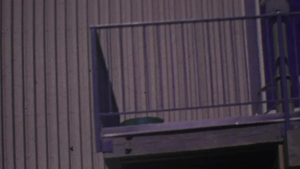 A Palm Springs tramway structure view with metal railings and corrugated siding as the passengers move largely out of the visible frame.