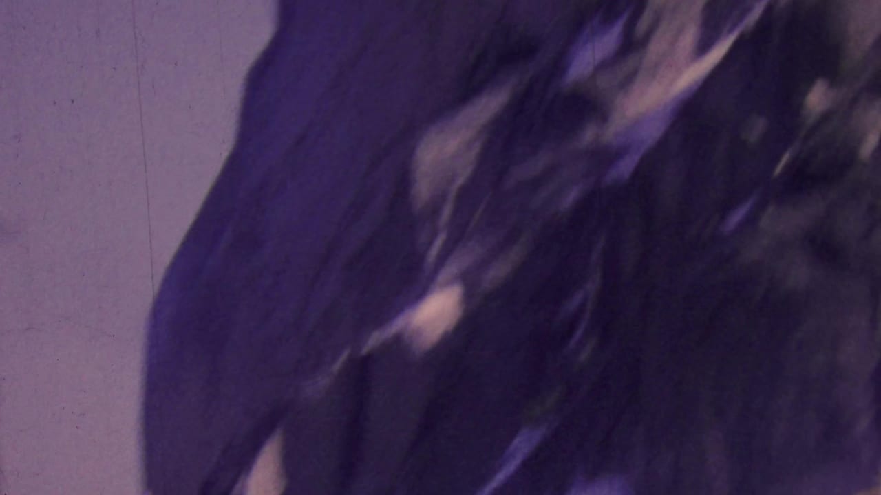 Dark rocky cliff face with pale sky and soft motion blur.