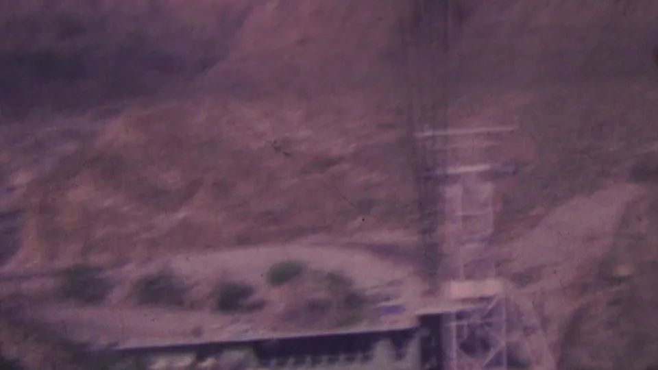 A motion-blurred 8mm view shows the Palm Springs tramway structure and tower against the canyon slope, emphasizing the handheld home-movie viewpoint.