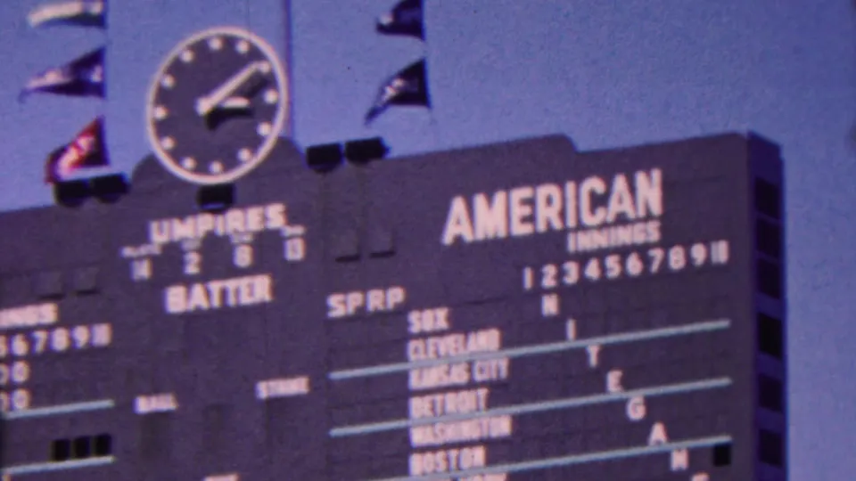 1963 Indiana frame centered on the American League scoreboard panel, with the analog clock and flags above and several team names and score columns visible.