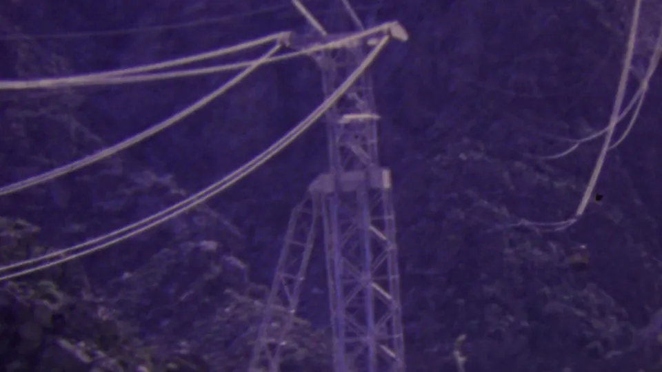 A support tower and sweeping aerial tramway cables appear against the Palm Springs mountain terrain, with the small tram car visible near the cable line.