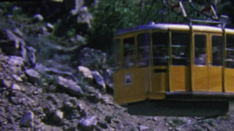 A closer cropped view shows the yellow aerial tram cabin moving past rocky Palm Springs terrain, with passengers faintly visible inside and foliage behind it.