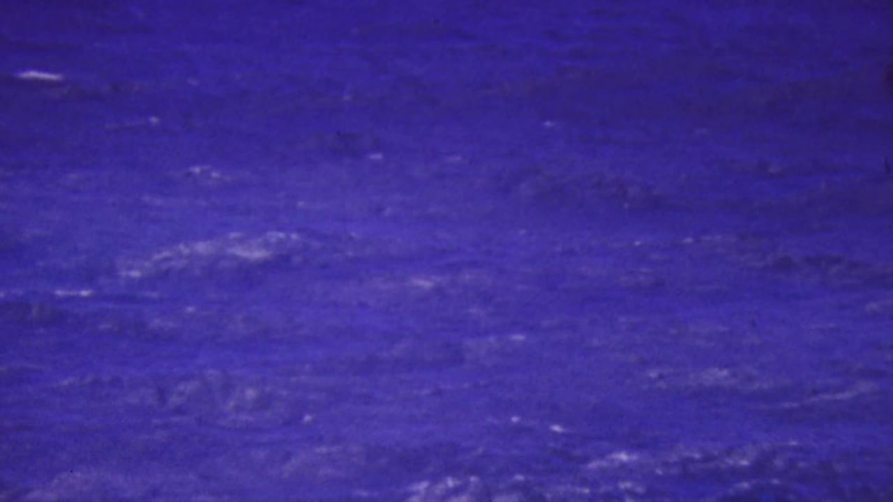 Dark blue choppy ocean water with faint whitecaps and purplish color shift.