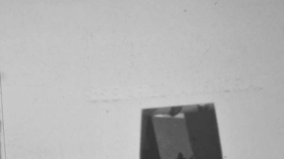 Black-and-white 1962 Pearl Harbor frame with much of the concrete structure washed bright, leaving a dark doorway area and faint wall lines visible.
