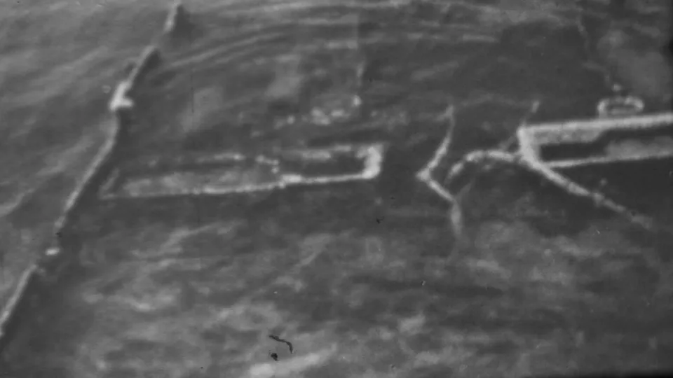 1962 Pearl Harbor, Honolulu 8mm frame showing blurred water, pale wave action, and angular wreckage-like forms along the coastal edge.