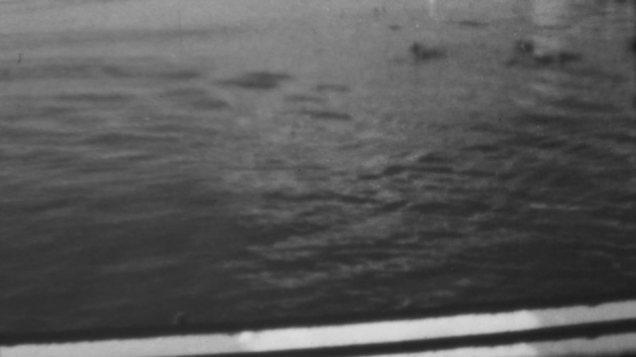 Close view of dark rippling water with soft reflections and film grain.