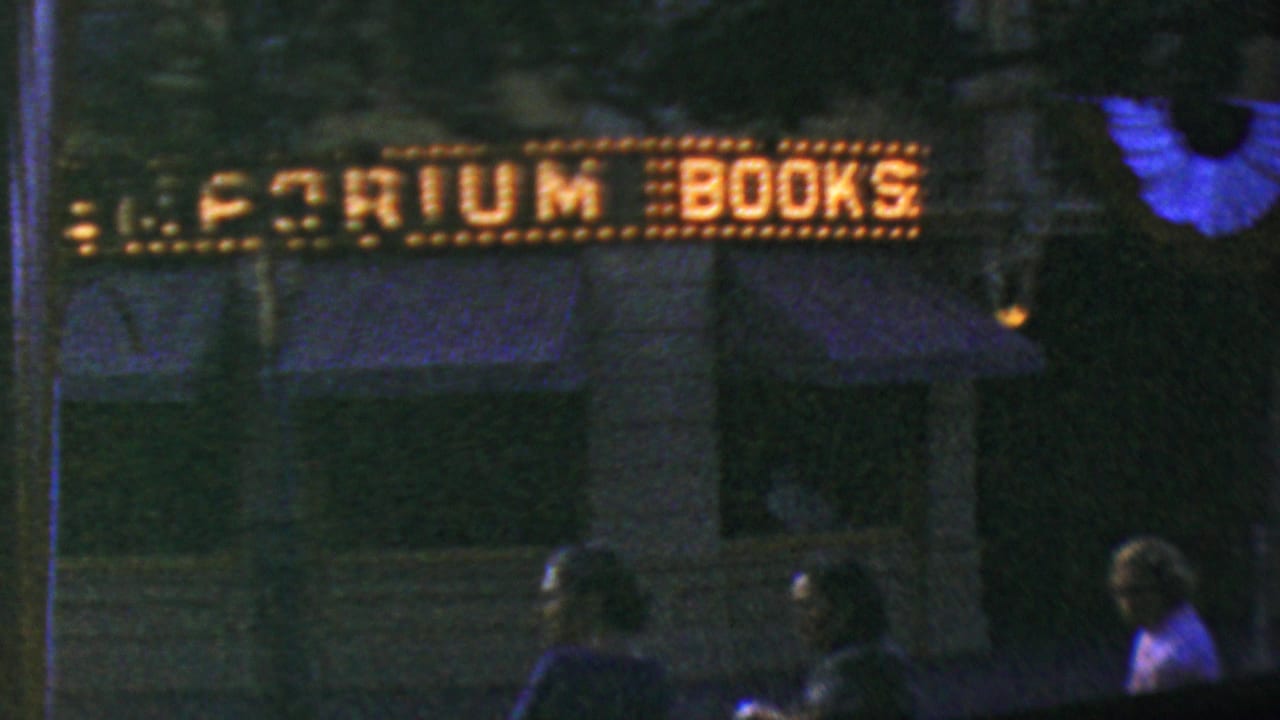 Scoreboard or sign reading Premium Books above a dim foreground with people partly visible.