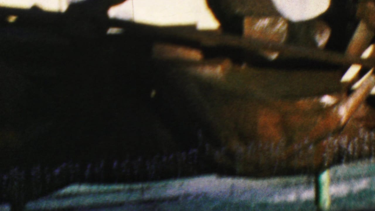 Close view of a dark metal figure and long rod-like element over fountain water.