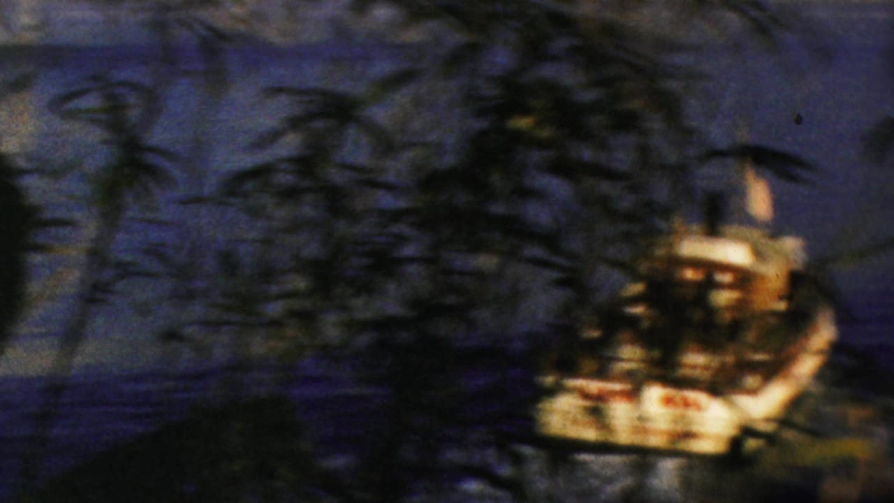 1964 Anaheim Disneyland home-movie frame showing a small lit boat on dark water, partly obscured by foreground reeds and night foliage.