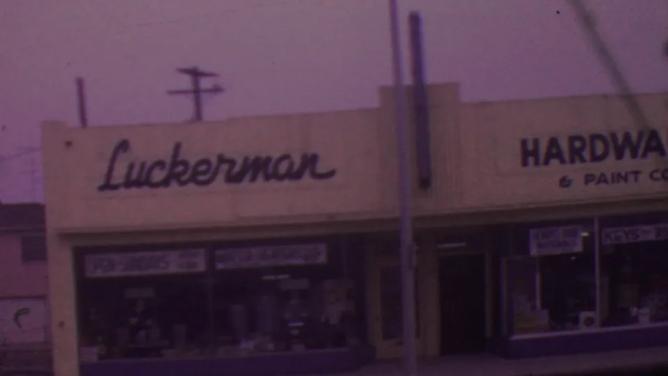 A closer 1965 Los Angeles view shows the Luckerman sign above glass display windows, with adjacent Hardware & Paint Co. lettering and a keys sign partly visible.