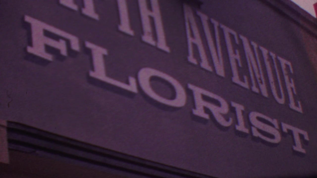 Angled 1965 Los Angeles view of the FIFTH AVENUE FLORIST sign, cropped tightly across the raised white letters and dark facade.
