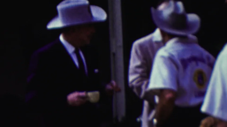 The final frame shows the suited man in a cowboy hat turned sideways toward other men in pale shirts and brimmed hats, continuing the brief outdoor social exchange in California in 1961.