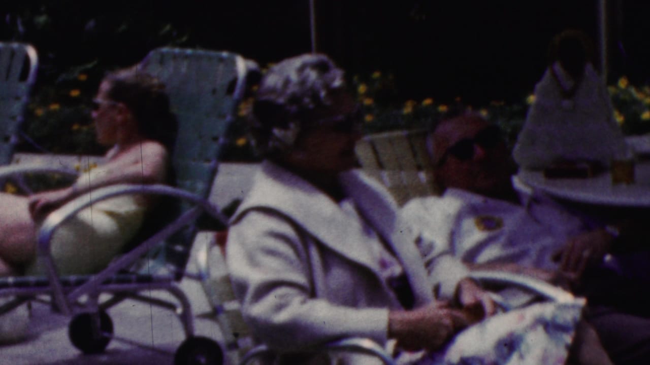 Women sit and recline on patio chairs while a person in a hat is partly visible at the edge of the frame.