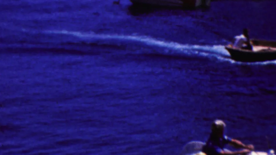 A small motorboat moves across deep blue water in 1961 California home-movie footage, leaving a bright wake behind it.