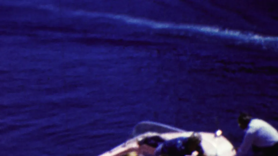 A motorboat travels across the water while nearby boat passengers appear at the lower edge of the 1961 California frame.