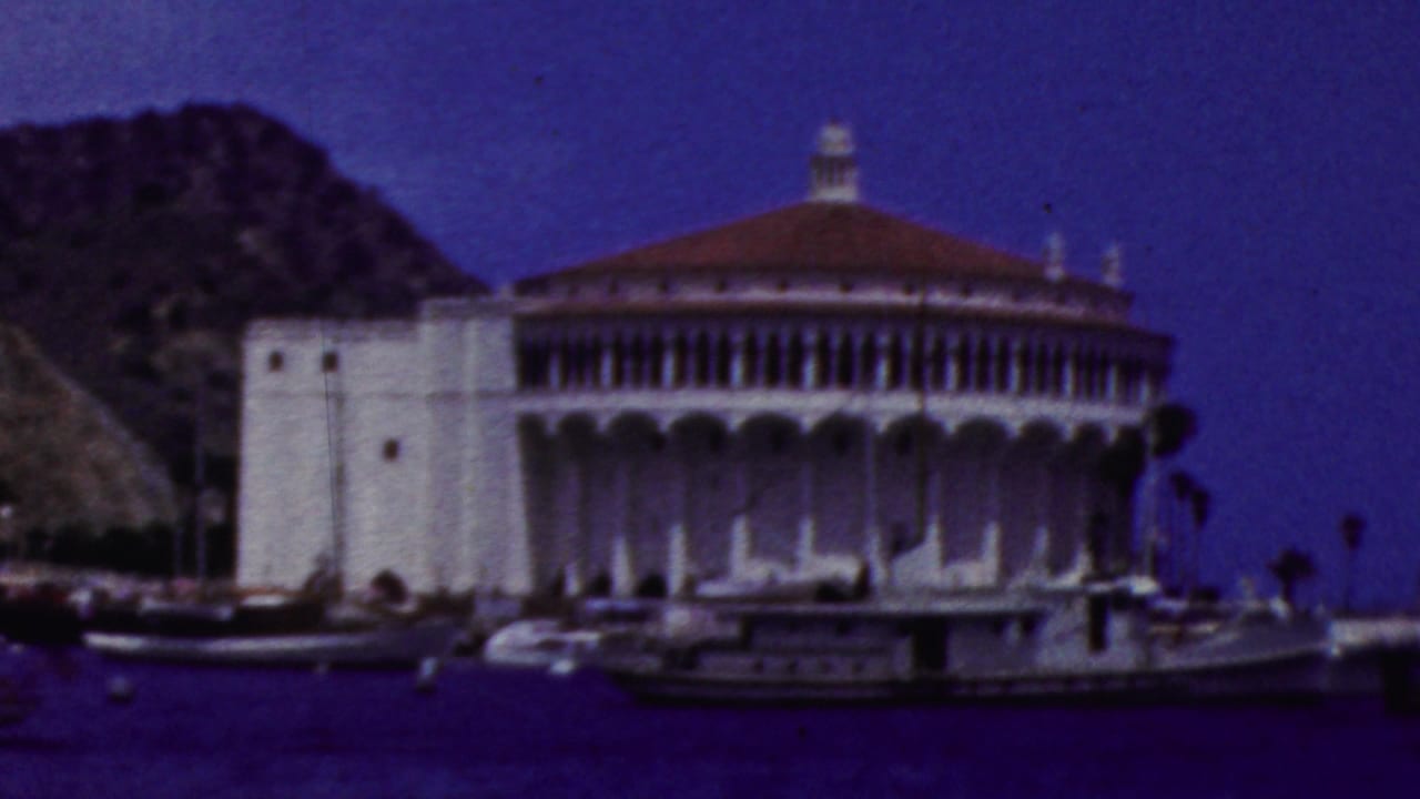 Catalina Casino with boats in the harbor and hillside behind it.