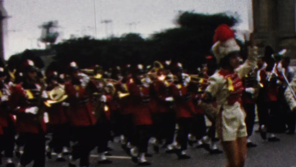 The final frame shows a cheerleader at the roadside edge and a red-uniformed brass marching band continuing through the 1961 California parade route.