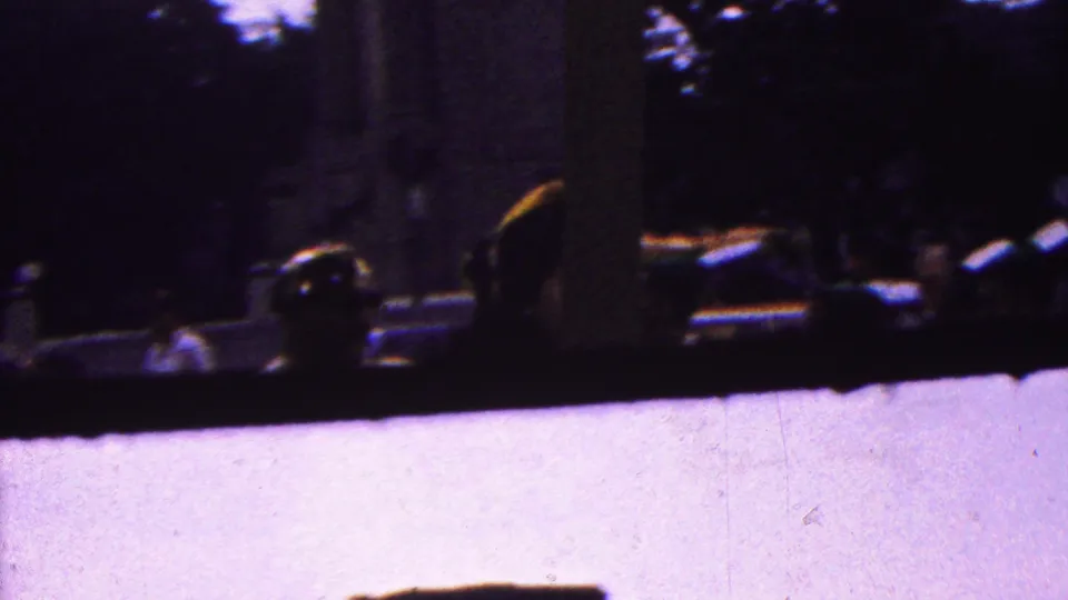 A darker handheld frame from the 1961 California footage shows indistinct people near what appears to be a vehicle or platform under trees, with heavy shadow and motion blur limiting detail.
