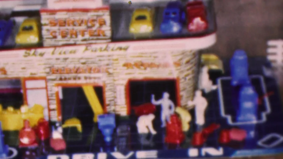 Final frame of the Cleveland 1953 toy service center scene, showing roof parking cars, small plastic figures, side stairs, garage openings, and Drive In lettering on the base.