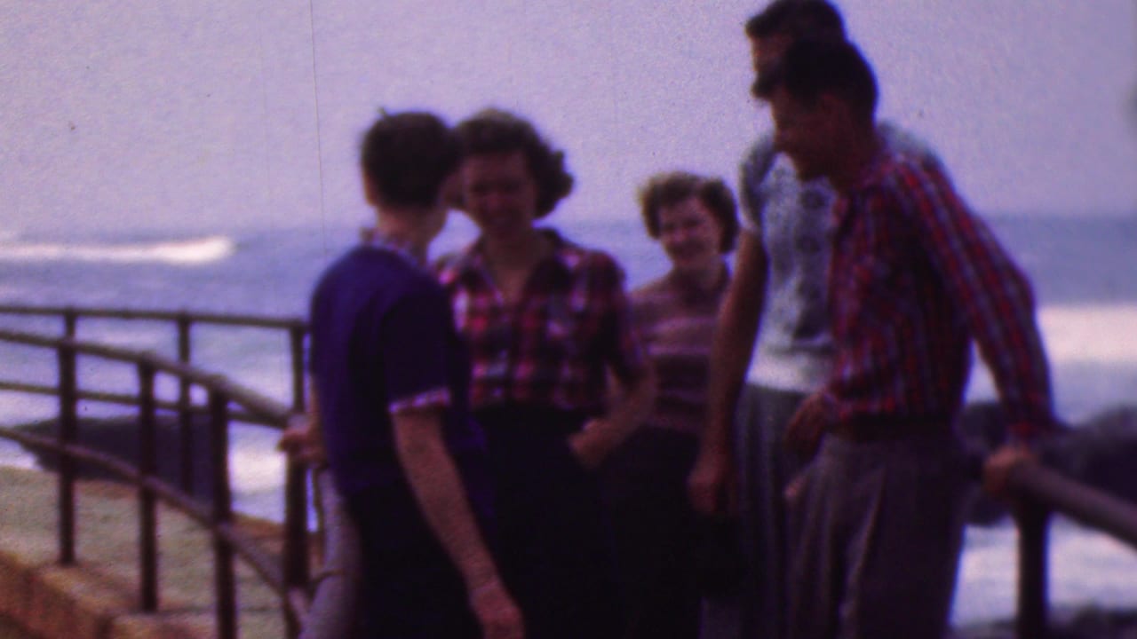 The group remains near the railing as one woman turns toward the others.
