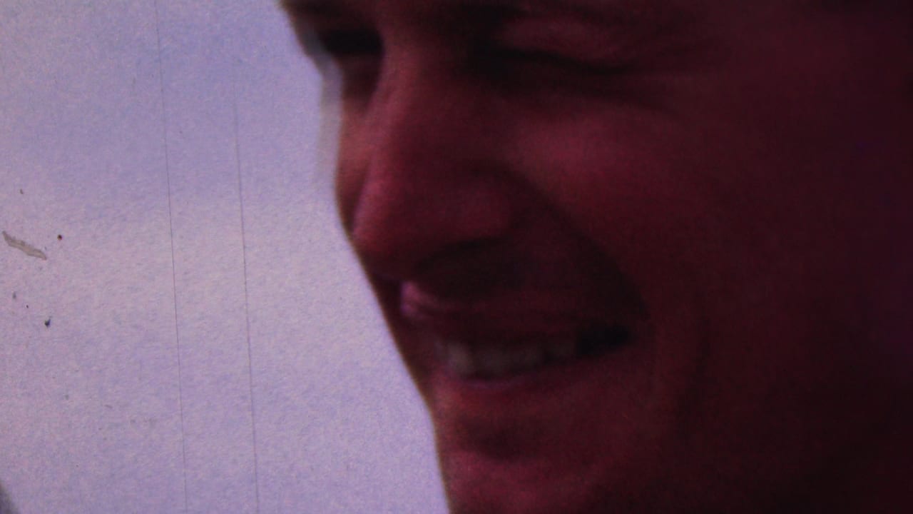 Close-up 1953 8mm home-movie frame of a smiling adult man, with soft focus, saturated color, and visible film marks; the Cleveland, Ohio attribution comes from clip metadata.