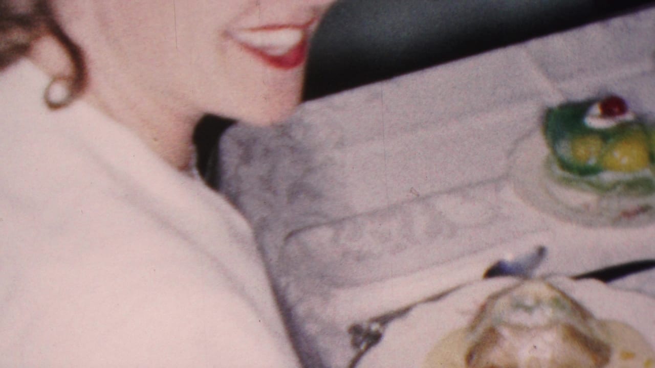 Woman seated at a dinner table beside a white tablecloth and gelatin dessert.