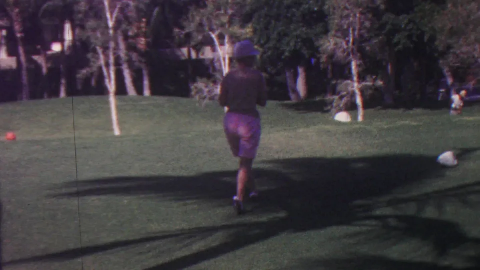A darker exposed frame shows the woman continuing across the Hawaii lawn with a croquet mallet, while a red ball, palms, deep shadows, and dense foliage remain visible.