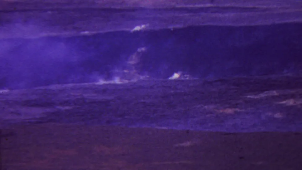 1962 Hawaii 8mm frame showing multiple pale steam plumes scattered along a dark volcanic surface with a soft, purple-tinted horizon.