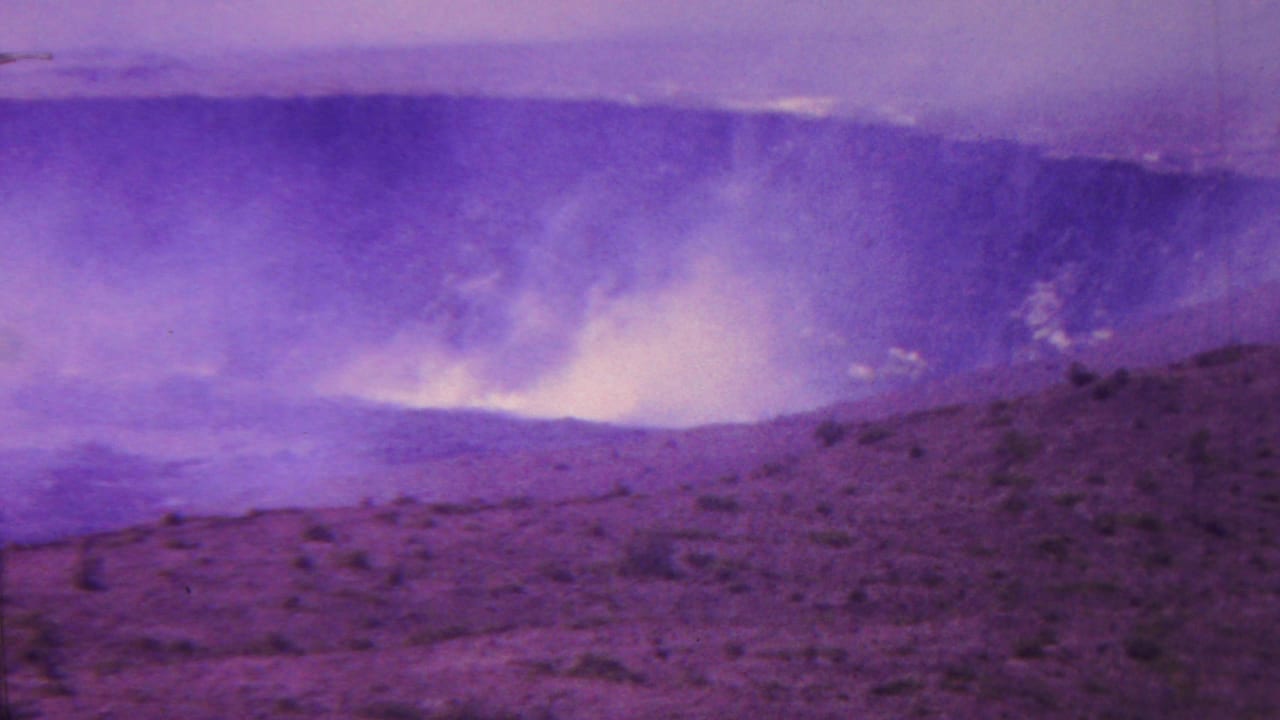 A wide crater landscape with a bright plume of smoke or steam near the far rim.