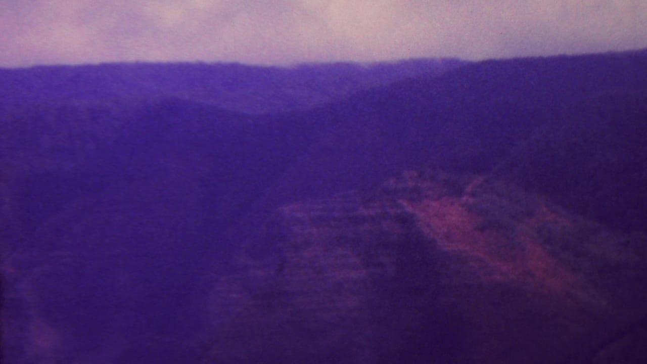 Distant ridgeline and shadowed canyon walls in a purple faded landscape.