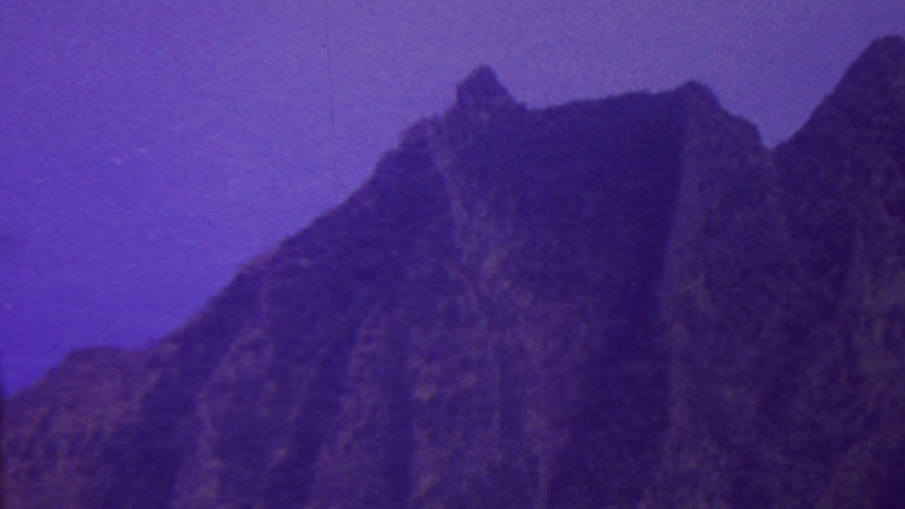 Steep craggy mountain slope with pointed ridge forms.