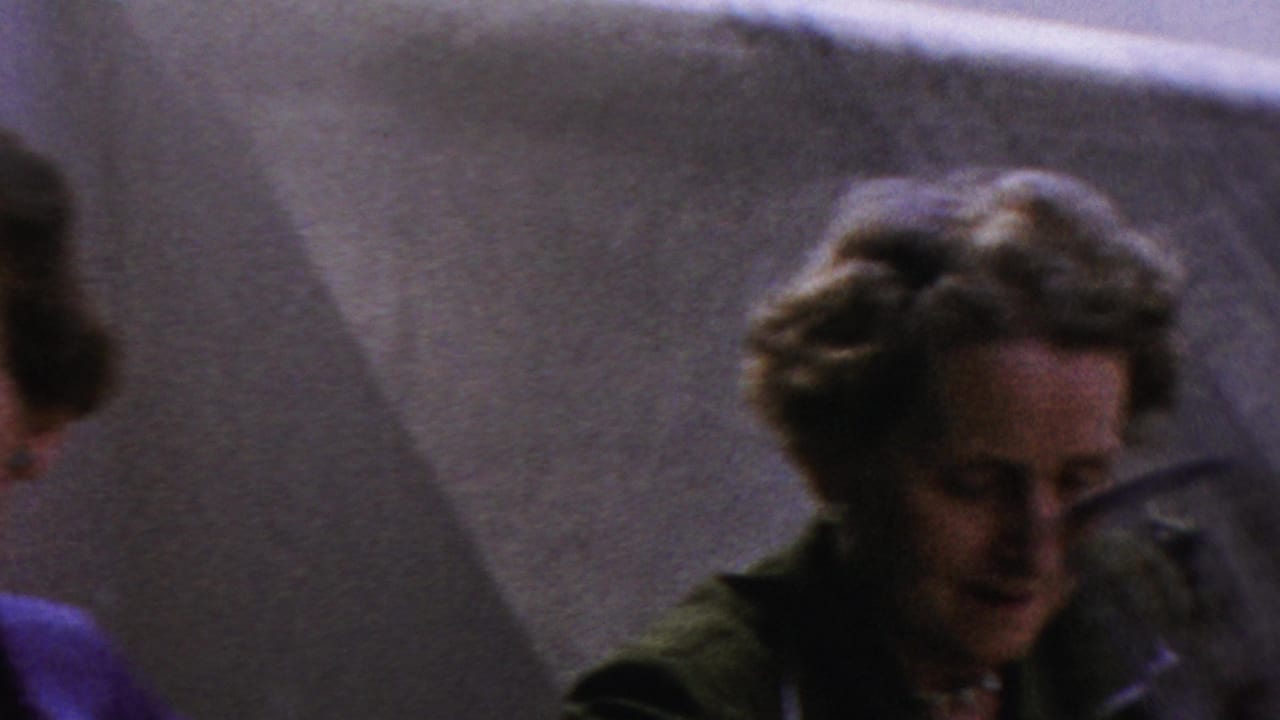 The final frame shows the woman lower in the composition and partly obscured by nearby adults, maintaining the candid home-movie view of the 1954 Columbus family event.