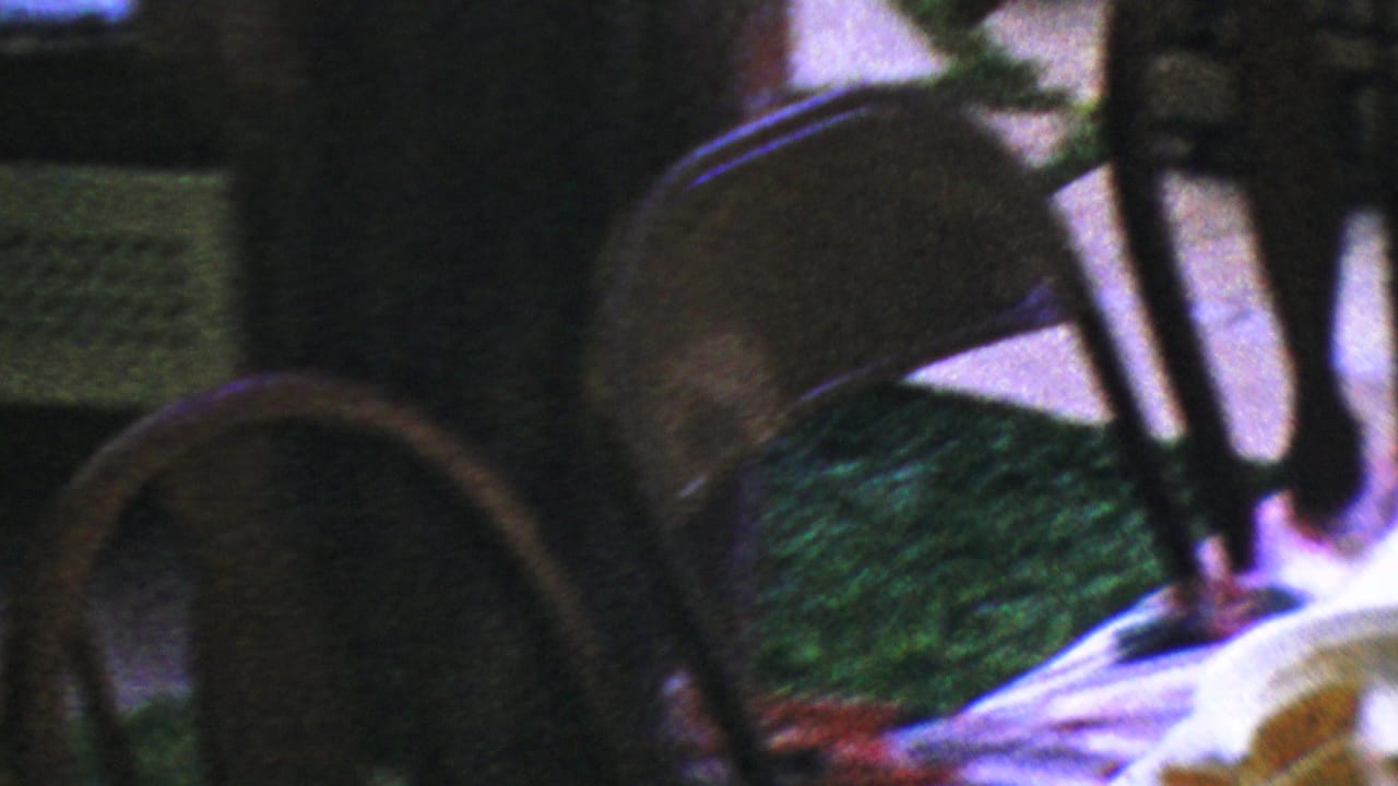 Wooden dining chairs and part of a table setting are visible in a dim Columbus, Ohio home interior from the 1954 footage.