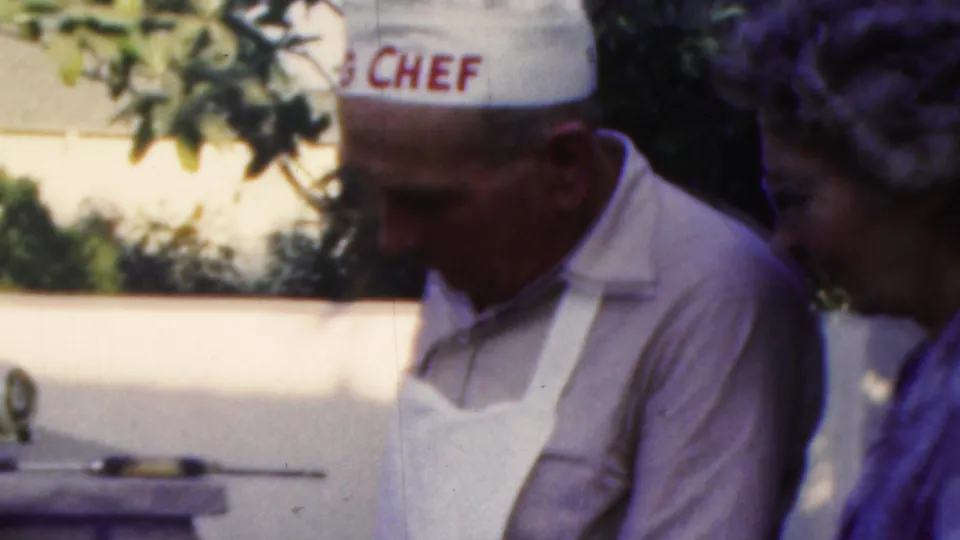 A man wearing a white apron and chef hat with red lettering appears to prepare food outdoors during the 1949 Seaside, New Jersey celebration.