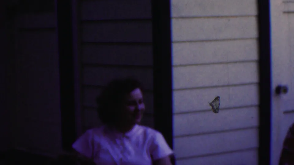 A woman in a light-colored top or dress sits near the table as the man is partly visible at the edge, suggesting a couple waiting in the 1949 Seaside, New Jersey scene.