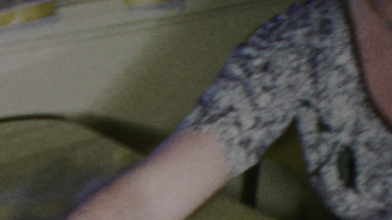 Partial 1949 Seaside, New Jersey home-movie frame showing two women close together indoors, one in a patterned dress with an arm extended toward the pregnant woman.
