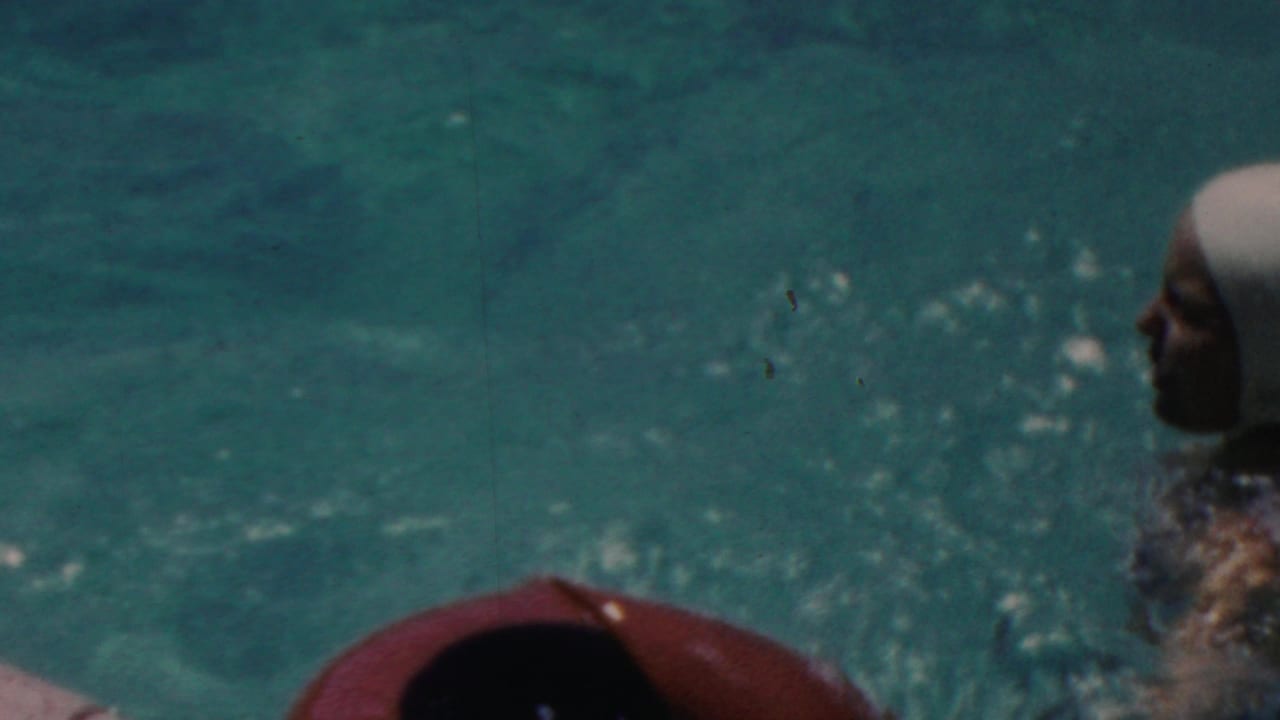 The swim-capped woman remains near the pool edge as bubbles and turquoise water fill the frame in this 1949 Seaside, New Jersey 8mm shot.