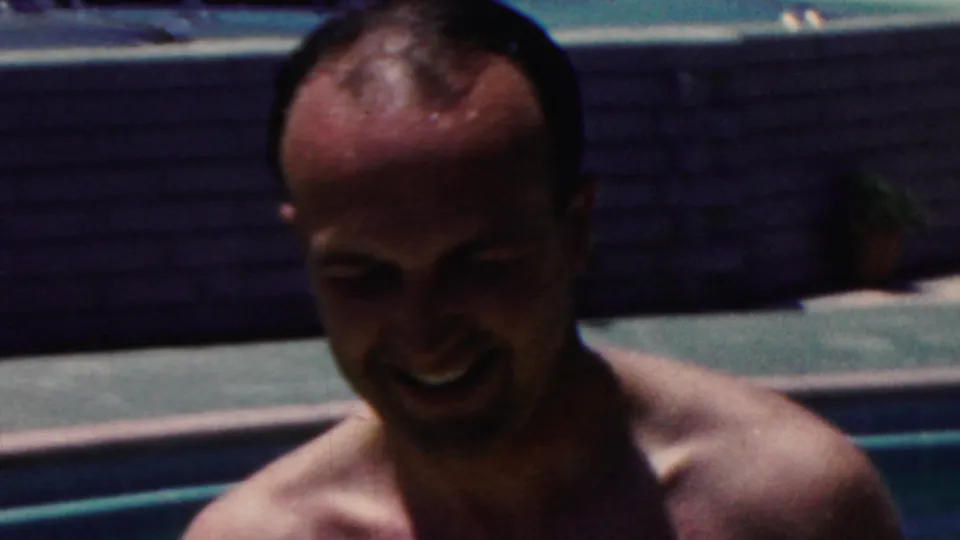 A smiling shirtless man stands near the pool edge, filmed close-up in grainy 8mm color in the supplied 1949 Seaside, New Jersey footage.