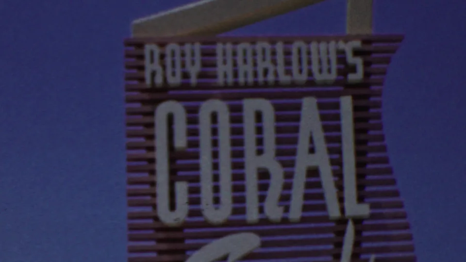 A final frame holds on the "Roy Harlow's Coral" sign, showing the white lettering, pink backing, diagonal support, and blue sky.
