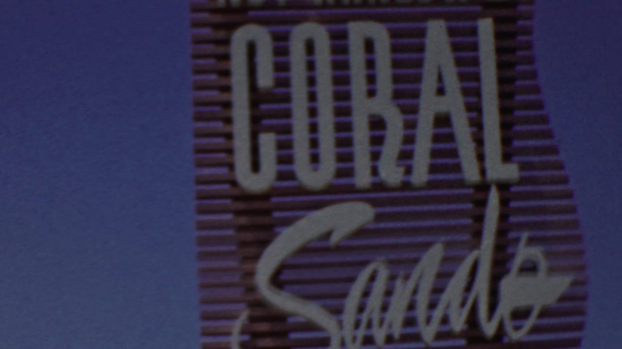 Close view of the Coral Sands sign with large block letters and script.