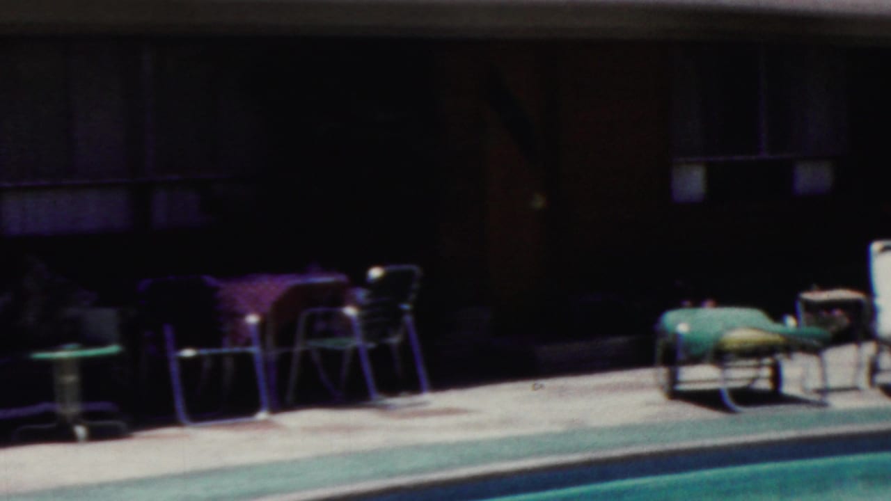 1949 Seaside, New Jersey poolside frame showing lounge chairs, small tables, and a shaded building facade in soft 8mm color.